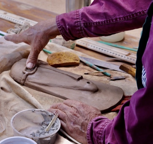 Person hand building with clay slabs with tools on a table