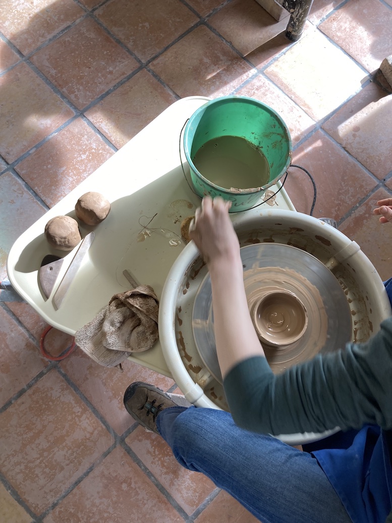 Aerial view of person making pottery on a wheel