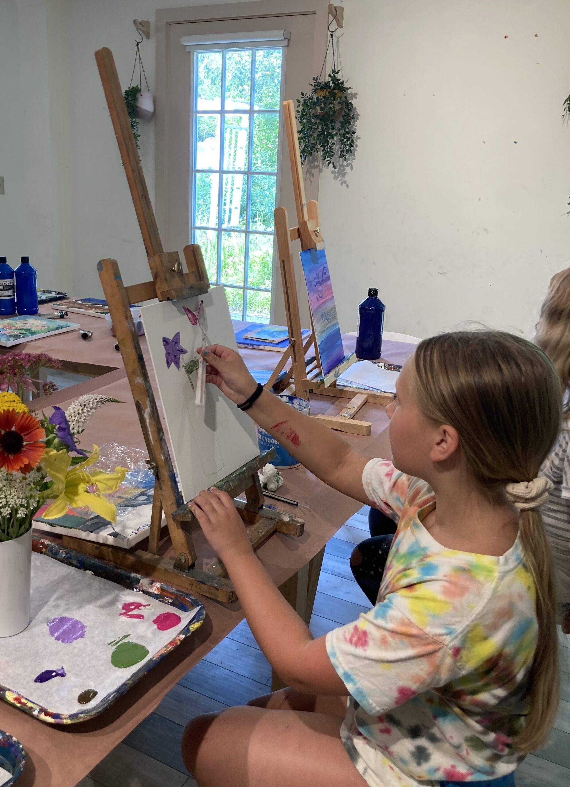 Girl painting in an art studio using an easel