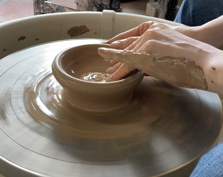 close up of hands making bowl on a potter's wheel