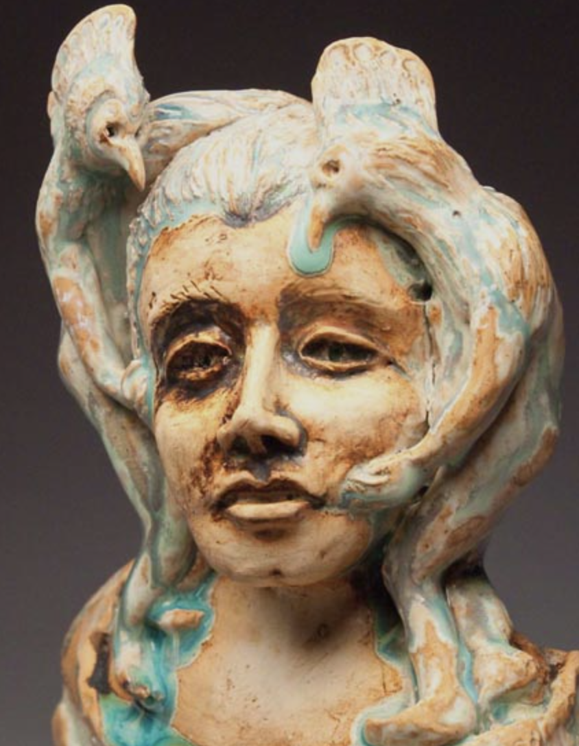 clay sculpture of head with birds