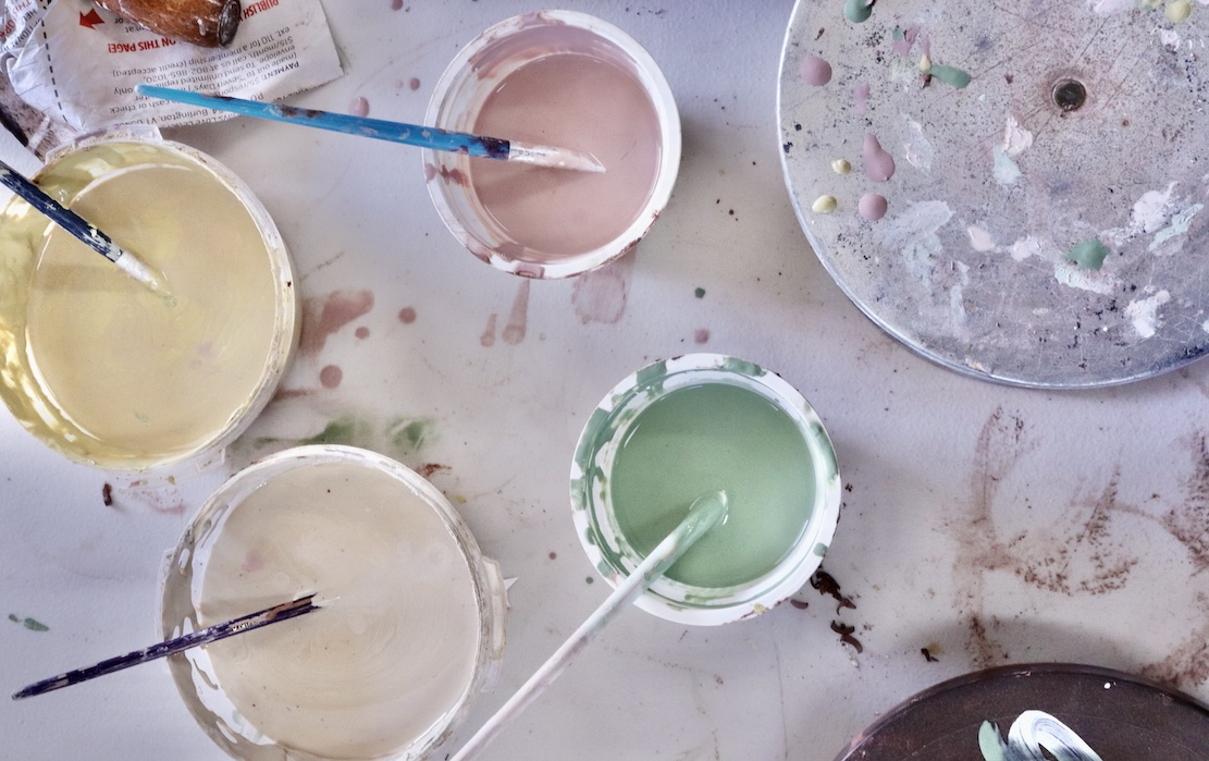 colored slips and a banding wheel on a table