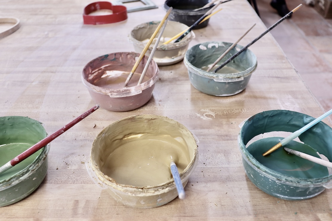 colored slips with paintbrushes on a table