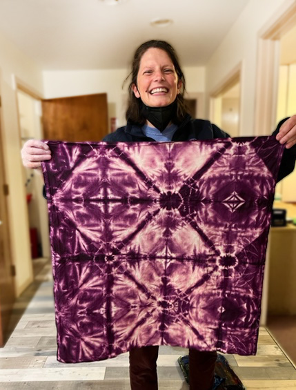 woman holding purple tea towel with geometric designs