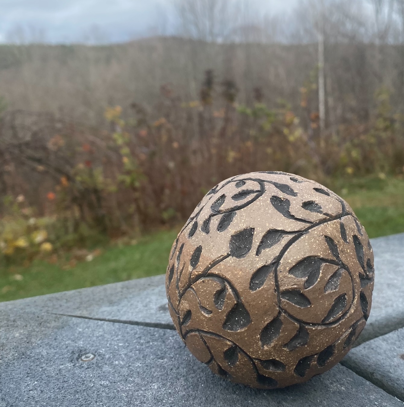 Clay ball sculpture with carving of leaves