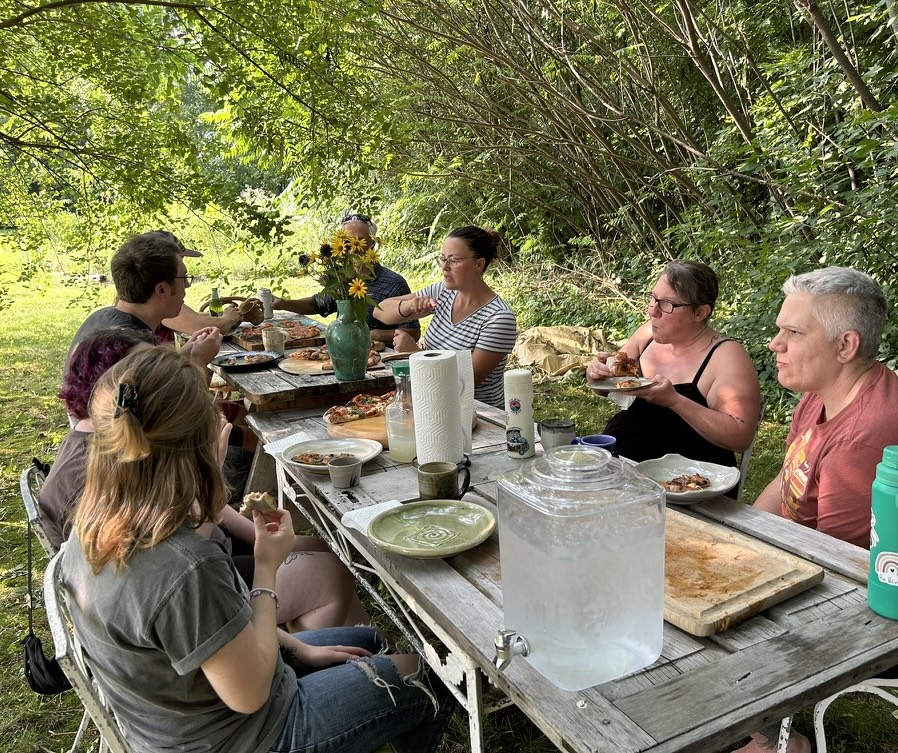 People eating pizza outside 